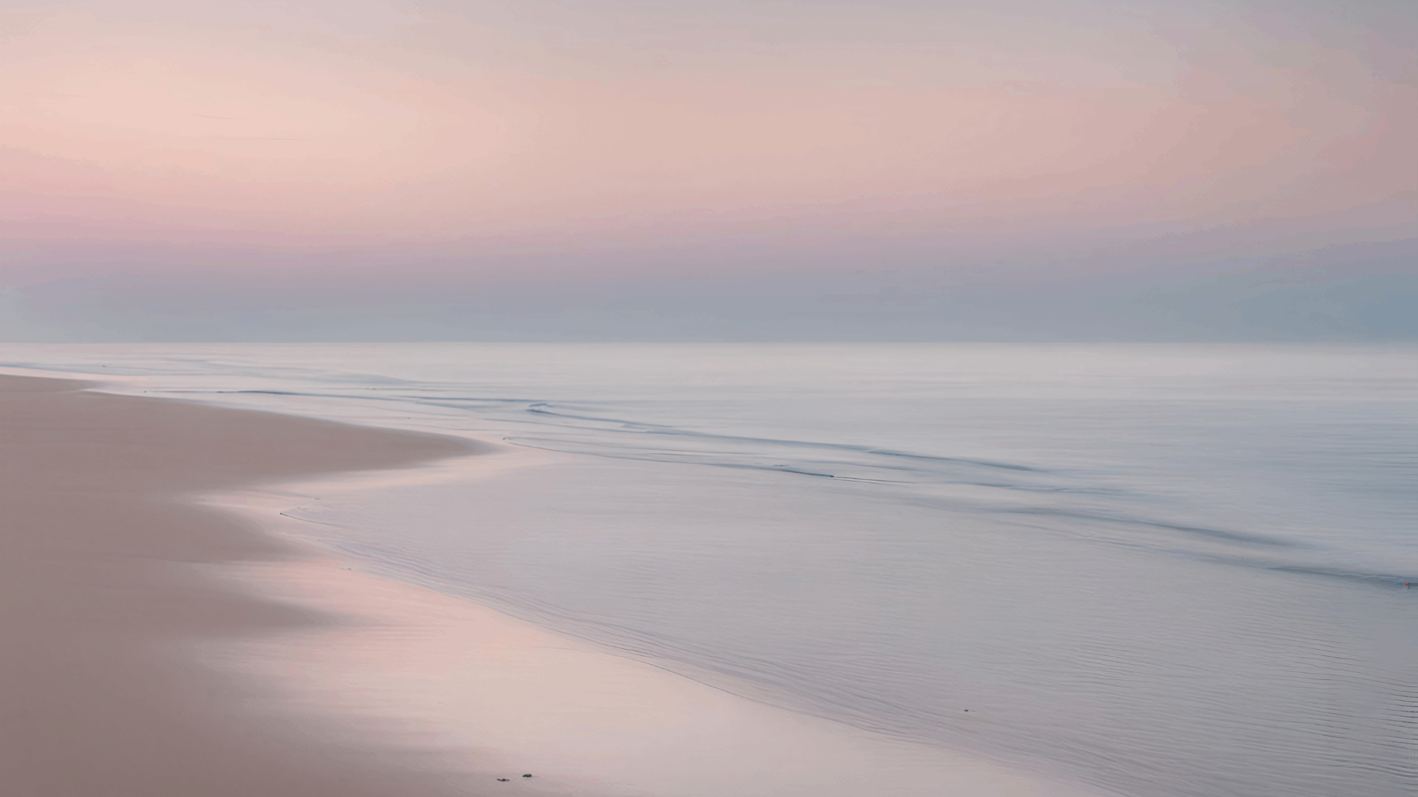 Low tide lapping on the beach during a soft sunrise.