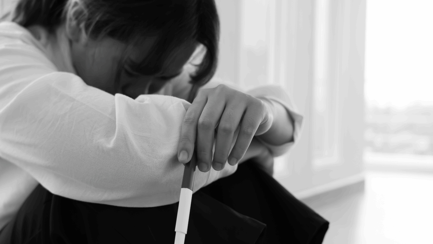 Image of woman with her arms wrapped around her legs and head in her knees.